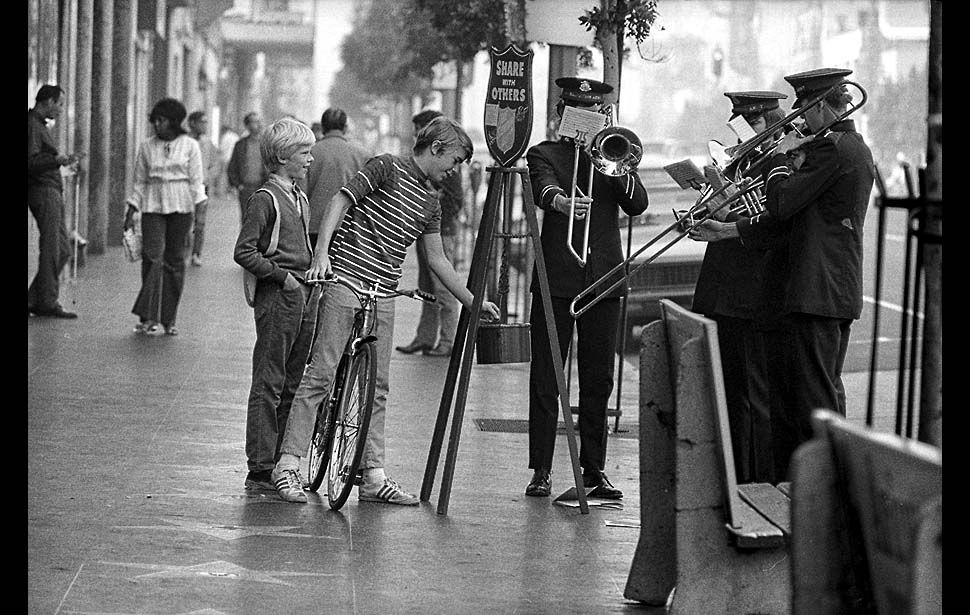 Dec. 20, 1971: Youth on bicycle drops some change into Salvation Army kettle located at corner of Hollywood and Vine while a traditional, four-piece brass band plays a selection of Christmas carols